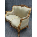 A CARVED GILTWOOD LOUIS XV STYLE SETTEE WITH MOULDED FRAME AND FLORAL MOTIFS. W.132cms.