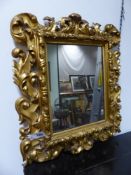 A CARVED GILTWOOD FLORENTINE MIRROR IN THE BAROQUE TASTE. H.66cms, W. 56cms.