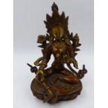 AN EASTERN BRONZE FIGURE OF A SEATED DEITY ON A LOTUS FORM BASE. H.21cms.