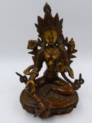 AN EASTERN BRONZE FIGURE OF A SEATED DEITY ON A LOTUS FORM BASE. H.21cms.