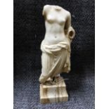 AN EARLY CARVED MARBLE FIGURAL FRAGMENT OF A SEMI-DRAPED FEMALE, LATER MOUNTED ON A MARBLE BASE.