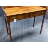 A MAHOGANY EARLY VICTORIAN GALLERY BACK TWO DRAWER WRITING TABLE WITH RING TURNED TAPERED LEGS. W.