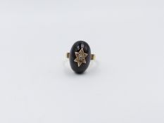 A 22ct WEDDING BAND MOUNTED WITH AN EARLY VICTORIAN OVAL CABOCHON GARNET RING DECORATED WITH A SIX