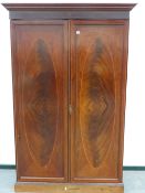 A 19th.C.MAHOGANY HANGING WARDROBE WITH CROSSBANDED AND IINLAID PANEL DOORS STANDING ON PLINTH BASE.