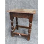 AN EARLY OAK JOINT STOOL WITH CARVED FRIEZE. W.46cms.