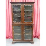A 19th.C.WALNUT TWO PART DISPLAY CABINET WITH FOUR SHAPED PANEL GLAZED DOORS ENCLOSING SHELVES. W.