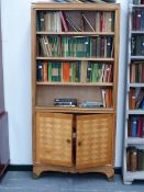 AN INTERESTING MID CENTURY SATINBIRCH BOOKCASE CABINET WITH BRASS MOUNTED FEET.