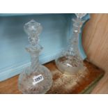 TWO ANTIQUE CUT GLASS DECANTERS AND THREE SILVER MOUNTED BUTTON HOOKS.