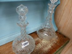 TWO ANTIQUE CUT GLASS DECANTERS AND THREE SILVER MOUNTED BUTTON HOOKS.