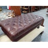 A LARGE LEATHER UPHOLSTERED STOOL.