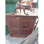 A LATE GEORGIAN OAK TWO DOOR CORNER CABINET.