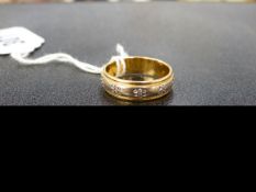 A 18ct. TWO COLOUR GOLD WEDDING BAND.