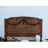 A CARVED WALNUT HEADBOARD.