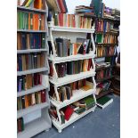 AN ANTIQUE PAINTED WATERFALL BOOKCASE WITH SERPENTINE SUPPORTS AND PIERCED DECORATION.