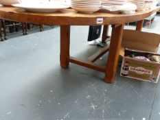 A LARGE OAK EXTENDING DINING TABLE ON REFECTORY TYPE BASE.