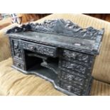 A JAPANESE CARVED AND EBONISED TABLE CABINET.