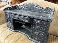 A JAPANESE CARVED AND EBONISED TABLE CABINET.