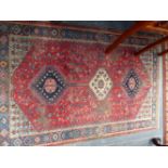 A SMALL RED GROUND HAND WOVEN EASTERN RUG