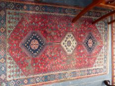 A SMALL RED GROUND HAND WOVEN EASTERN RUG