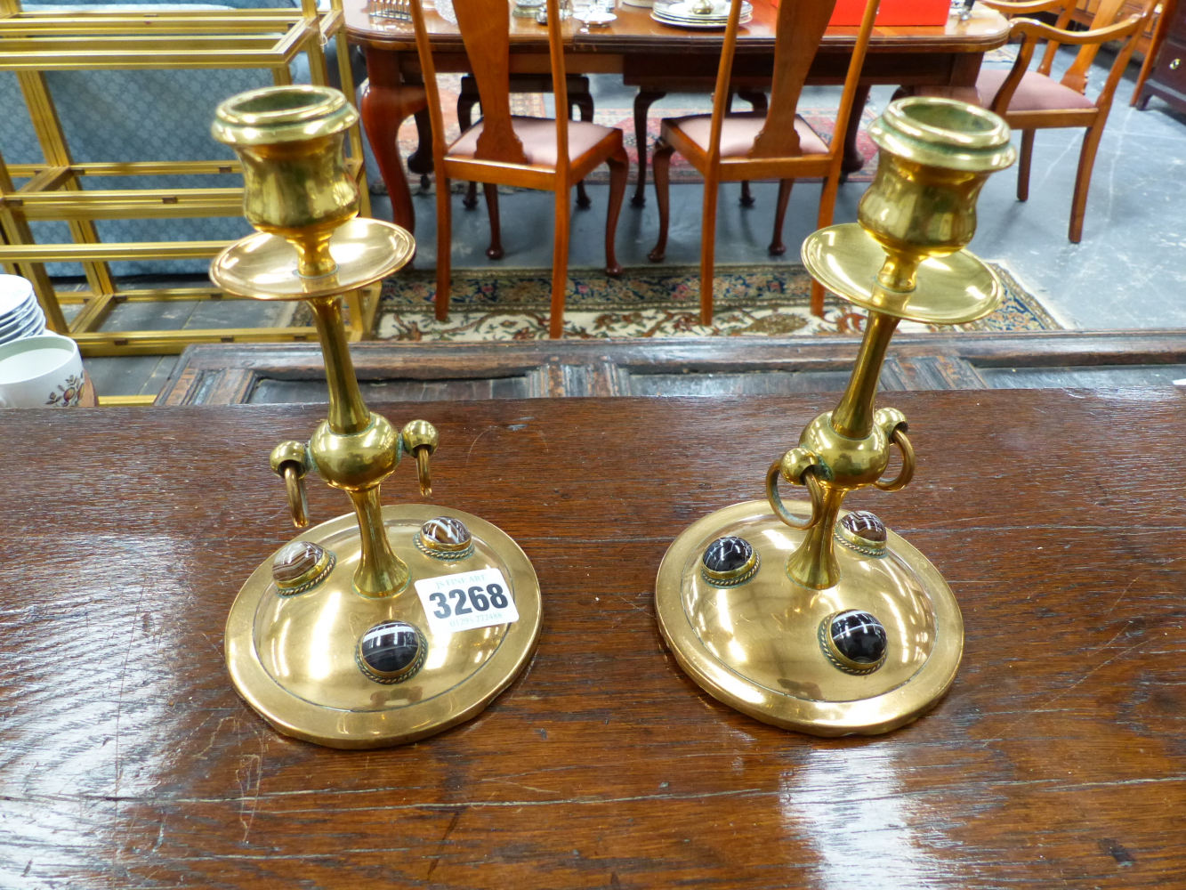 A PAIR OF ARTS AND CRAFTS BRASS CANDLESTICKS INSET WITH CABUCHON STONES