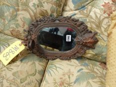 A DECORATIVE SMALL WALL MIRROR.