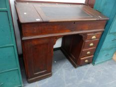 AN ANTIQUE OAK CLERK'S DESK ON TWIN PEDESTAL SUPPORTS.