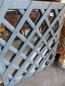 A PAINTED FRAMED LATTICE MIRROR.