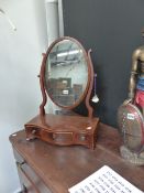 A REGENCY SWING MIRROR IN SERPENTINE BASE.