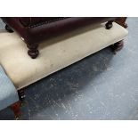 A LARGE BANQUETTE STOOL ON TURNED LEGS AND BRASS CASTERS.