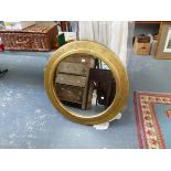 A LARGE GILT FRAMED CIRCULAR MIRROR.