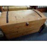 AN ANTIQUE PINE DOME TOP BLANKET BOX.