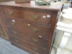 AN EDWARDIAN OAK CHEST OF DRAWERS.