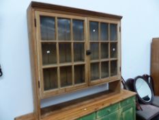 AN ANTIQUE GLAZED PINE CABINET.