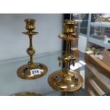 A PAIR OF ARTS AND CRAFTS BRASS CANDLESTICKS INSET WITH CABOCHON STONES.