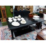 A LARGE EXTENDING EBONISED DINING TABLE.