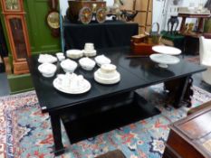 A LARGE EXTENDING EBONISED DINING TABLE.