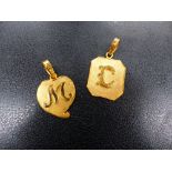 TWO 22ct INITIAL PENDANTS.