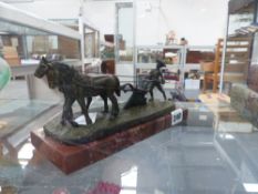 A BRONZE FIGURE OF A PLOUGHMAN AND TEAM MOUNTED ON A MARBLE BASE.