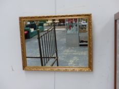 A GILT FRAMED MIRROR.