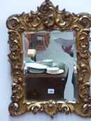 A GILT FRAMED MIRROR.