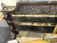 A CARVED OAK SHELF UNIT.