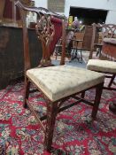 FOUR CARVED MAHOGANY CHIPPENDALE STYLE CHAIRS WITH PIERCED SPLATS AND BLIND FRET FRONT LEGS.