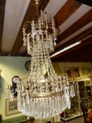 A NEOCLASSICAL STYLE BRASS FRAME CRYSTAL HUNG CHANDELIER OF WATERFALL FORM WITH SIX LIGHTS. H.