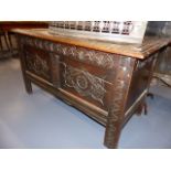 AN 18th.C.OAK COFFER WITH CARVED PANEL AND FRIEZE FRONT. W.129cms.