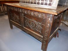 AN 18th.C.OAK COFFER WITH CARVED PANEL AND FRIEZE FRONT. W.129cms.