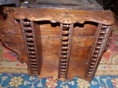 A VICTORIAN CARVED OAK THREE TIER WALL SHELF WITH SPINDLE GALLERIES.