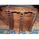 A VICTORIAN CARVED OAK THREE TIER WALL SHELF WITH SPINDLE GALLERIES.