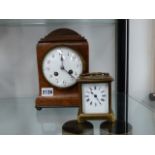A BRASS CASED CARRIAGE CLOCK AND A WALNUT MANTLE CLOCK.