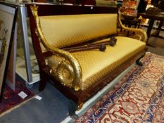 A CONTINENTAL MAHOGANY EMPIRE STYLE SETTEE WITH CARVED GILTWOOD SCROLLING DOLPHIN FORM ARMS AND