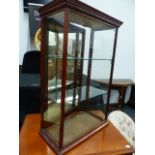 A LATE VICTORIAN MAHOGANY FRAMED SHOP COUNTER DISPLAY CABINET WITH MIRRORED REAR DOOR.